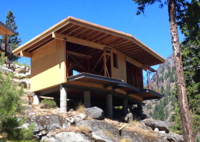 Framed cabin, side view, on steep mountain side.